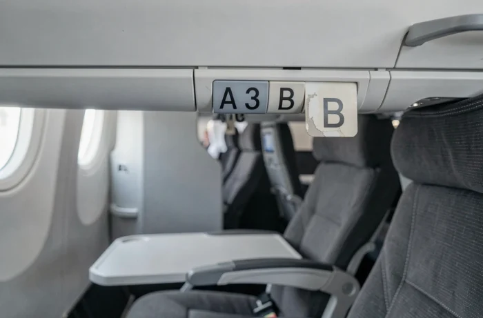 Gros plan sur le panneau de rangée numéro 13 dans un avion, avec les lettres de sièges A, B et C visibles en cabine économique